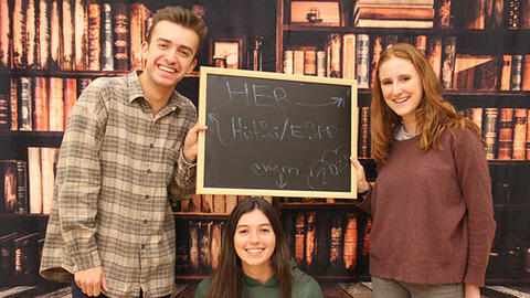 students holding a whiteboard that says their concentration