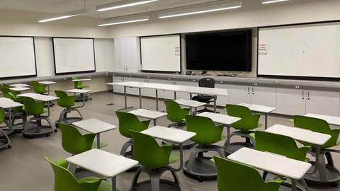 Photo of smart classroom with rows of desk and mounted TV