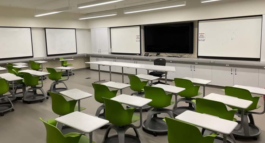 Photo of smart classroom with rows of desk and mounted TV