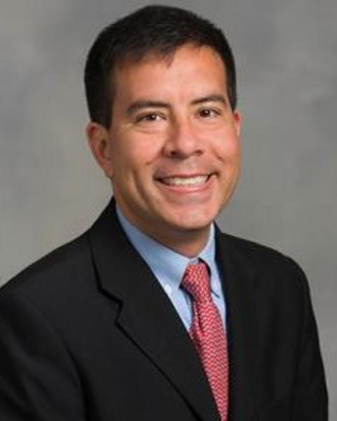 Headshot of Curtis wearing a dark business suite