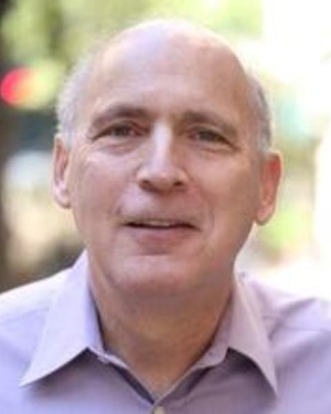 headshot of Jonathan wearing a purple button up shirt