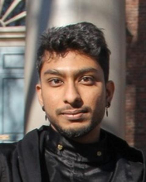 Phot of Sunera with a red brick building and blue door in the faded background
