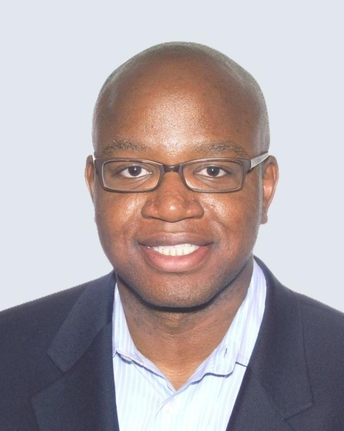 headshot of Johnson facing the camera wearing glasses and a dark suit