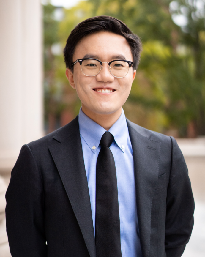 headshot of Brain facing the camera in a dark suit with a light blue shirt