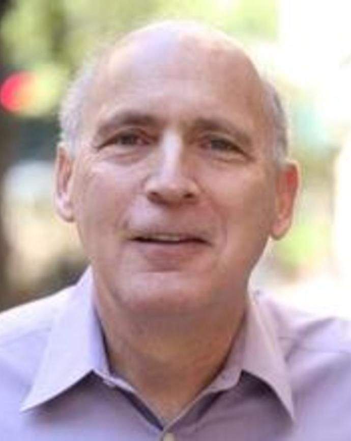 headshot of Jonathan wearing a purple button up shirt
